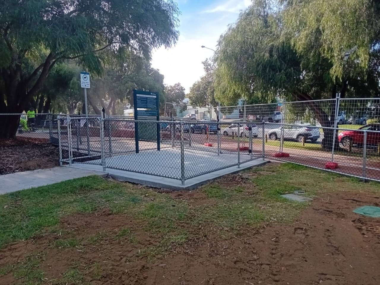 Chainmesh entry pen with gates on a concrete pad at a park